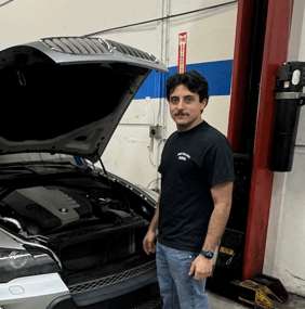 a man standing in front of a car with a car in the background