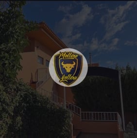 Entrada exterior de Yellow Cannabis Club con logotipo destacado