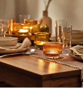 a table setting with a candle lite up in the middle of the table