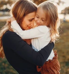 Una madre abrazando a su hija símbolo del amor incondicional de una madre