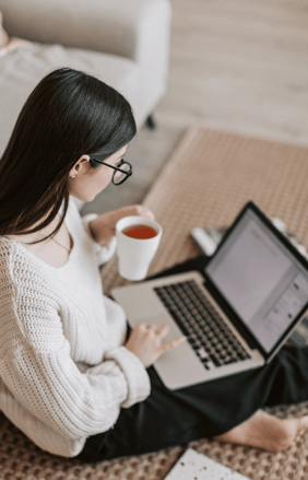 Woman learning about fertility options online with laptop and coffee.
