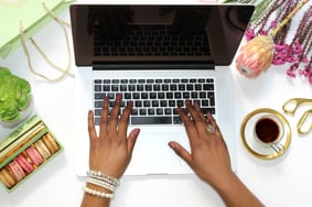 a woman's hands typing on a laptop computer