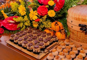 Deliciosos doces decorados com chocolate e cobertura de amendoim, rodeados por flores vibrantes, per