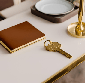 Clée d'hôtel posée sur un plateau doré, symbolisant le luxe et l'élégance dans le secteur hôtelier.