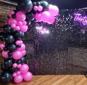 Black shimmer wall with pink neon and black balloon garland, pink Thirty neon for Kristen's 30th birthday.