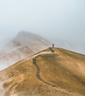 Une personne en haut d'une montage, elle a réussi à parcourir tout le chemin