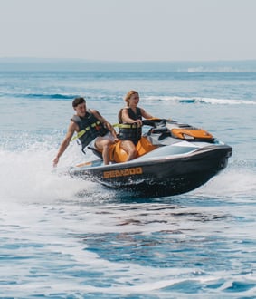 Happy couple riding a jet ski in Mallorca’s turquoise waters