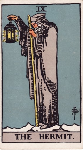uma carta de tarô mostrando o eremita de capuz segurando uma lanterna