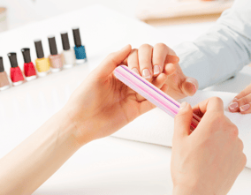 A lady is performing a manicure 