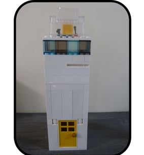 Faro de playa hecho con piezas de Lego, perfecto para construcciones de playa.