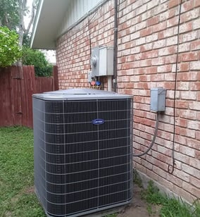a large air conditioner sitting on the side of a brick building