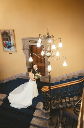 a bride and groom standing on a staircase way