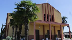 a church with a cross on the side of the road