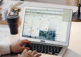 a person sitting at a desk with a laptop and trello