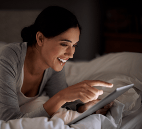 a woman is smiling and holding a tablet computer