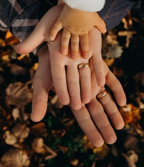 um casal de mãos dadas com alianças de casamento