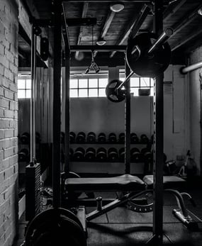 O sală de fitness dotată cu o bancă și o bară de greutăți.