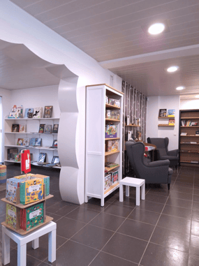 Photo de la transformation avec vue sur un coin lecture et un mur découpé en nuage
