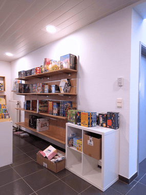 Aménagement du magasin de jouets avec des étagères murales en bois et des murs blancs
