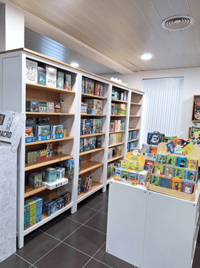 Aménagement du magasin de jouets avec des étagères blanches et un plan de travail comme présentoir