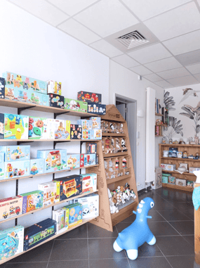 Magasin de jouets avec des étagères en bois et du papier peint fleuri