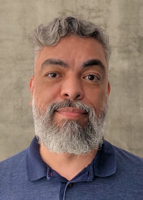 Cesar Felicio - Foto de perfil sobre um fundo acinzentado 