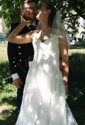 a man and woman in wedding attire standing in a field