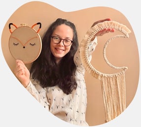 Mini Choum's : Créateur de décorations pour chambres d'enfant. Personne tenant une broderie totem re
