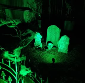 Glowing green backyard graveyard scene created by SweetAz Co. for a Halloween-themed house party in Redlands.