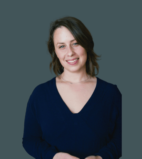 a photo of andree standing and smiling with a blue shirt on