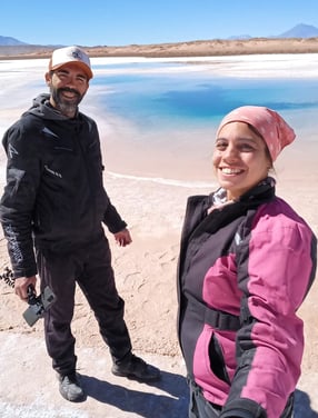 a man and woman standing on a beach cono de arita puna atacama salar ojos de mar salta