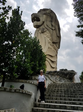 Lady poses beneath the Sentosa Merlion in Singapore