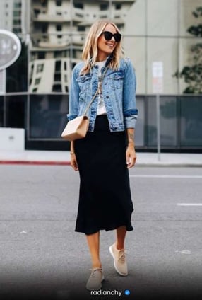 a woman in a black skirt and denim jacket