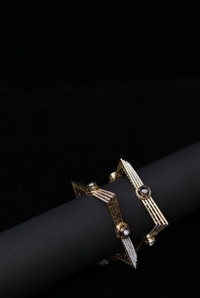 a pair of gold toned bracelets with a black and white bracelet portraitsbykaiff