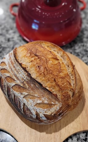Freshly baked artisan sourdough bread on wooden board