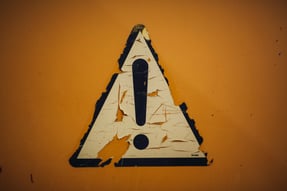 a sign that says caution on the side of a wall