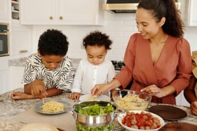 a woman and two children are cooking together