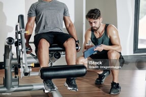 man sitting at leg extension exercise