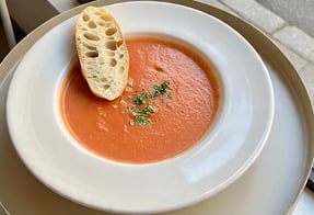 a bowl of soup with breaded bread on a table
