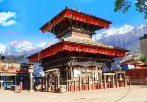 a temple with a red roof surrounded by snow mountains