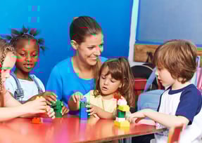 a woman and two children playing with blocks