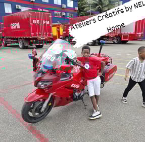 un enfant de l'atelier créatif devant une moto du GSPM