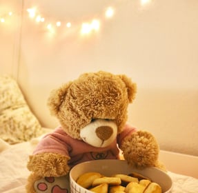 Photo montrant un ours en peluche devant un bol de friandises