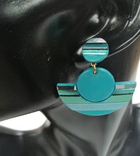 a woman's earring with a blue and green earrings