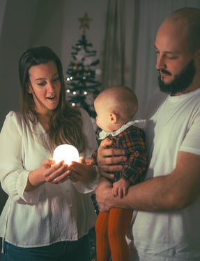 sesion fotografia de una familia en su casa en navidad jugando con una luz
