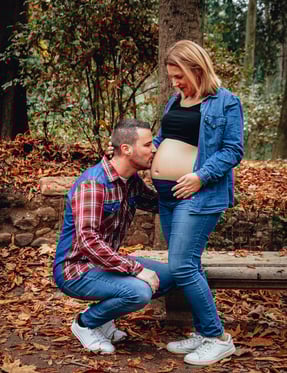 pareja dando un beso en la barriga embarazada de la madre