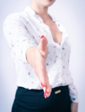 Outstretched hand ready for a handshake, representing connection, collaboration, or contacting us.