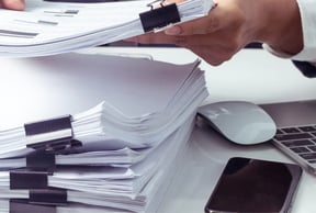 a person sorting documents to create a report