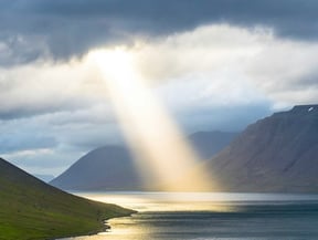 sunbeam coming through clouds onto water