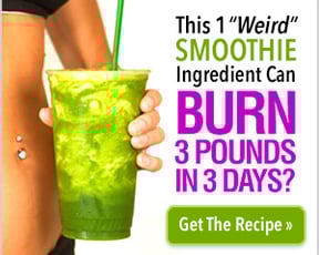 a woman holding a green smoothie in front of her stomach
